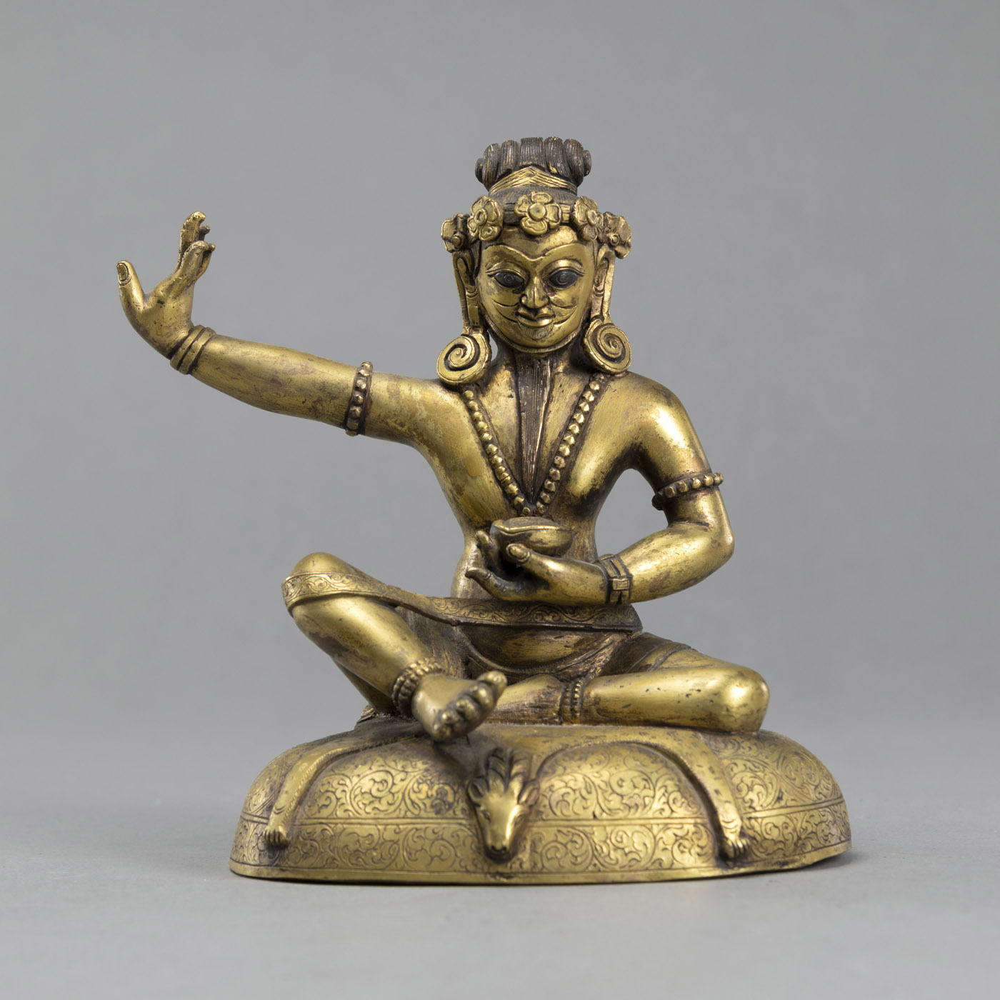 <b>Sitzender Mahasiddha aus feuervergoldeter Bronze auf einem Sitzkissen</b>