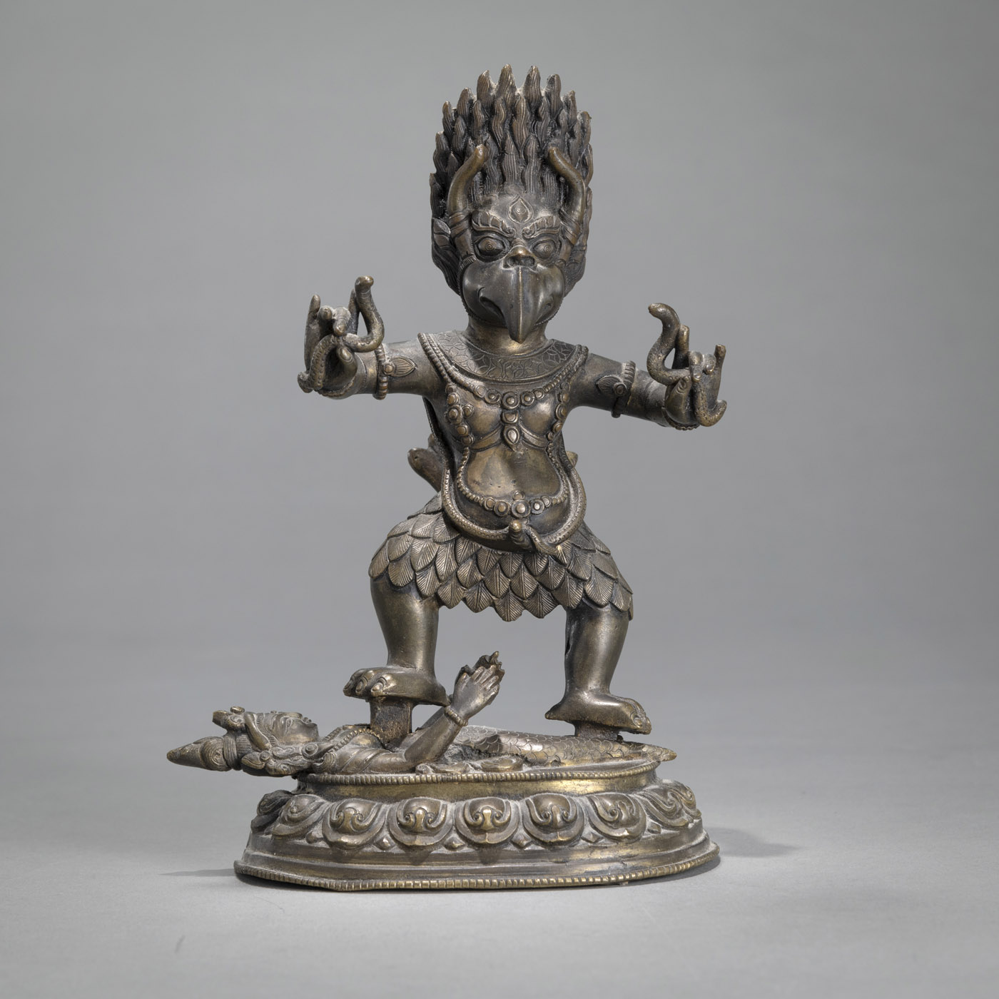 <b>A BRONZE TANTRIC WRATHFUL GARUDA STANDING ON A FEMALE DRAGON FIGURE ON A BASE</b>