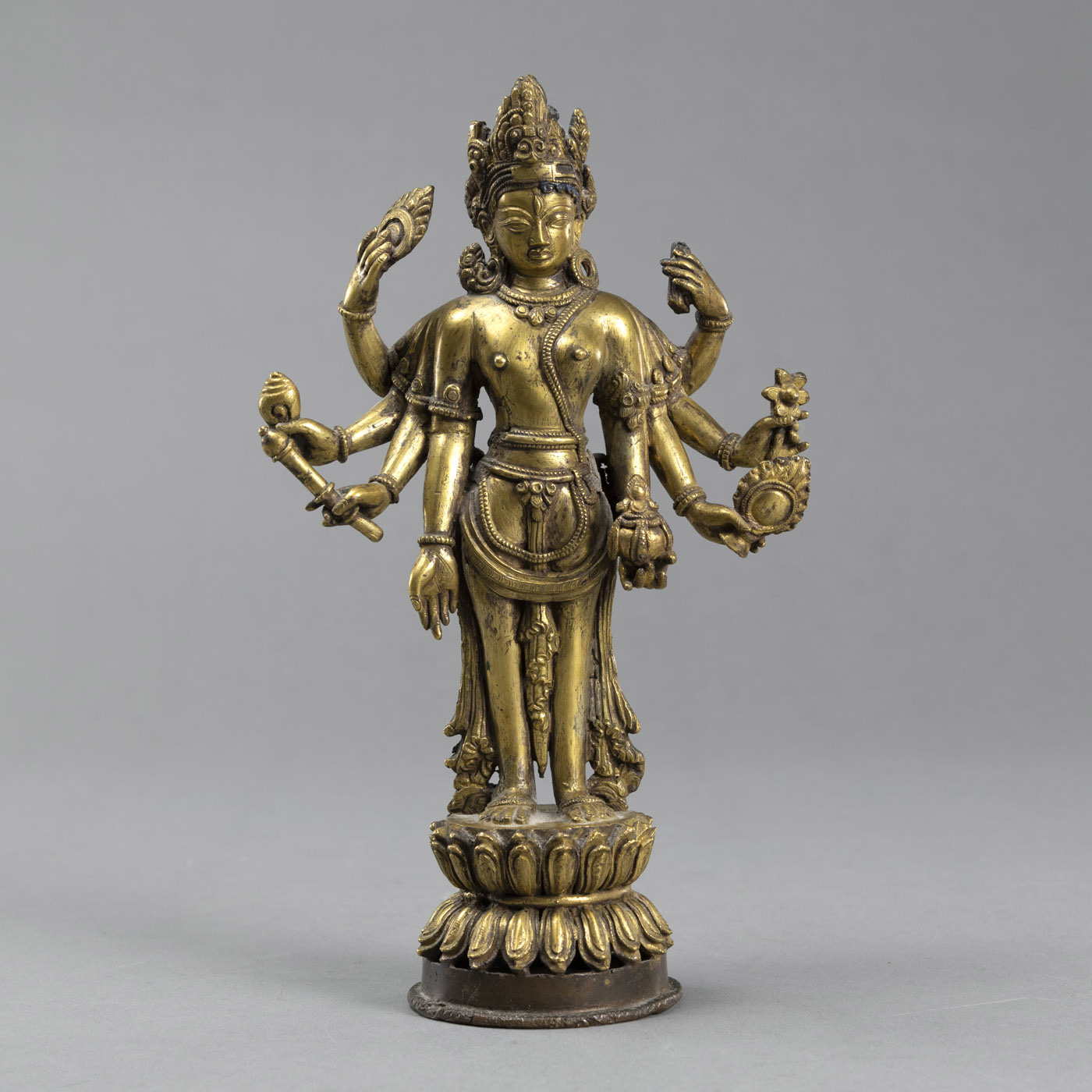 <b>Feuervergoldete Bronzefigur des stehenden achtarmigen Maitreya mit Attributen auf einem hohen Lotossockel</b>