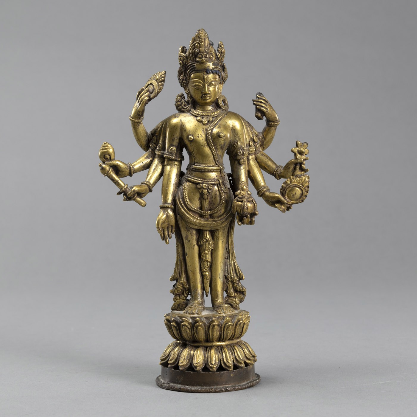 <b>A STANDING GILT BRONZE EIGHT-ARMED MAITREYA WITH ATTRIBUTES ON A LOTUS BASE</b>