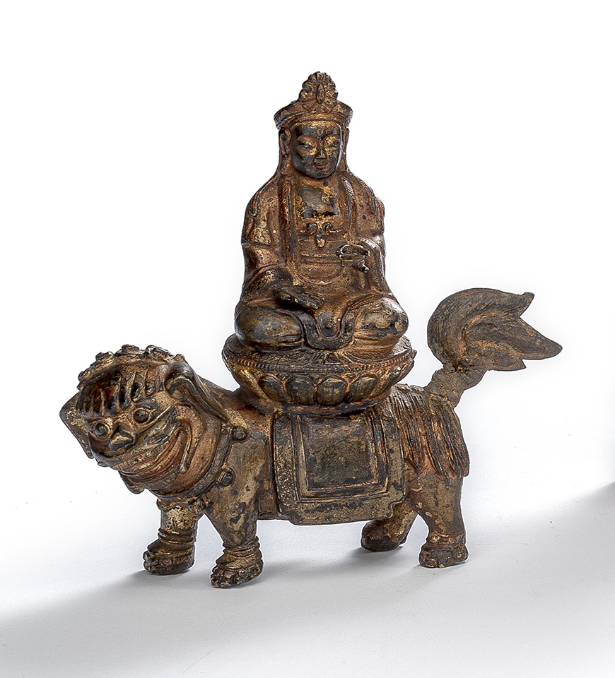 <b>A BRONZE FIGURE OF GUANYIN SEATED ABOVE A LOTUS ON A LION, REMNANTS OF GILDING</b>