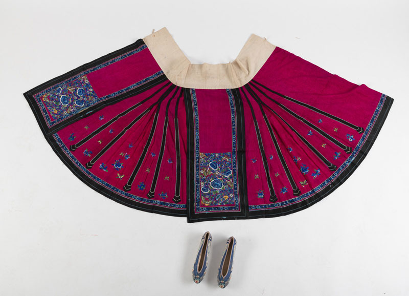 <b>LOT OF TEXTILES: A DRAGON ROBE FRAGMENT MOUNTED AS A CURTAIN, A RED SILK EMBROIDERED BED COVER WITH PHOENIX COUPLE, A WOMEN'S SKIRT AND A PAIR OF WOMEN'S SHOES</b>
