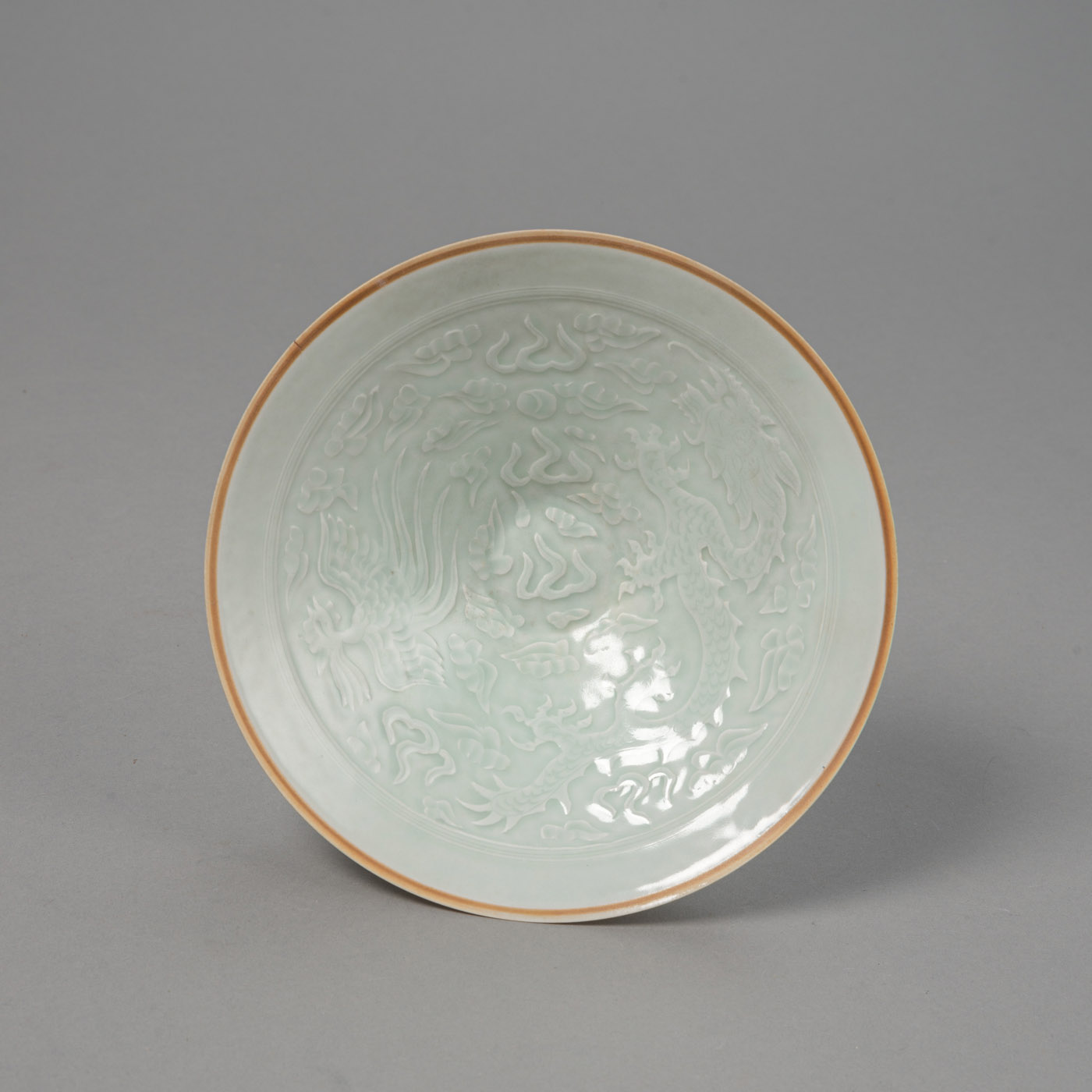 <b>Sehr dünnwändige konische Porzellanschale mit 'qingbai'-Glasur mit Drachen- und Phönixdekor in Relief, Boden und Lippe unglasiert</b>