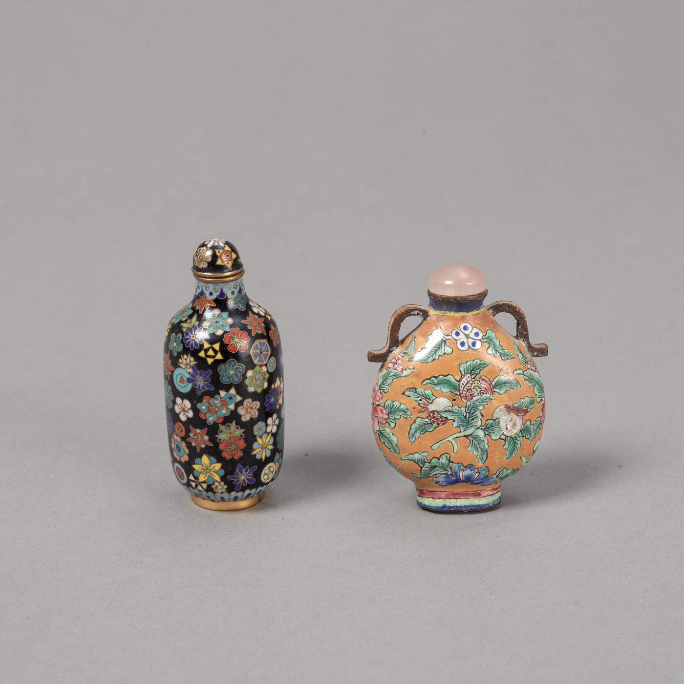 <b>Cloisonné-Snuffbottle mit Millefiori-Motiv auf schwarzem Grund und Kanton-Email-Snuffbottle mit Darstellung der 'sanduo'-Früchten</b>