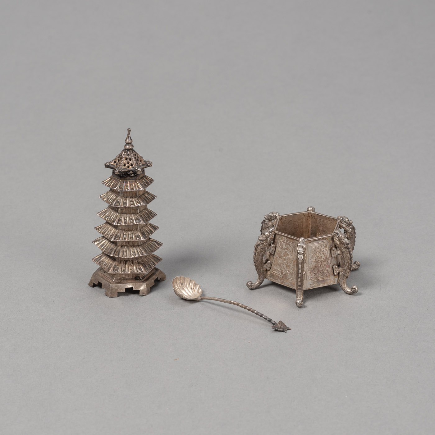 <b>A SILVER SALT SHAKER IN THE SHAPE OF A PAGODA WITH COVER AND A SMALL BOWL WITH A SPOON</b>
