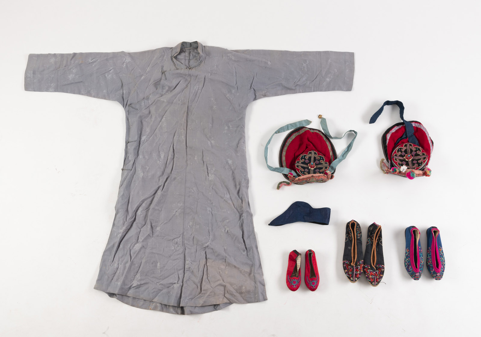<b>Konvolut Textilien: zwei Kinderhauben, drei Paare Schuhe, ein Sommergewand und ein Stirnband</b>