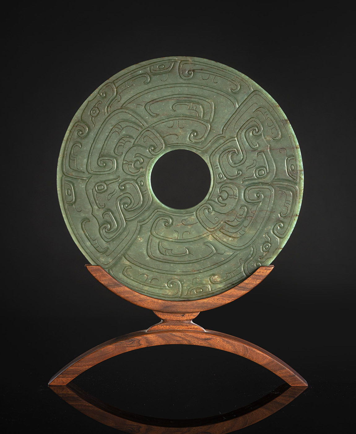 <b>A FINE CARVED SPINACH GREEN JADE BI IN ARCHAIC STYLE ON WOOD STAND</b>