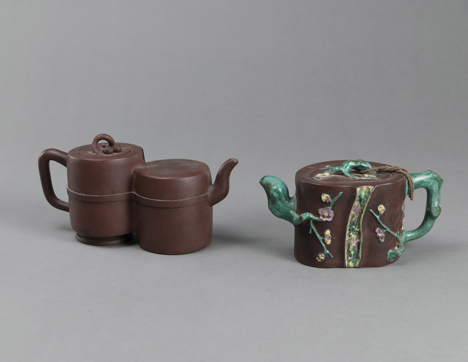 <b>Zwei Yixing-Teekannen in Form eines Doppelgefäße bzw. eines Pflaumenbaumstamms, teils gefasst mit Emailfarben</b>