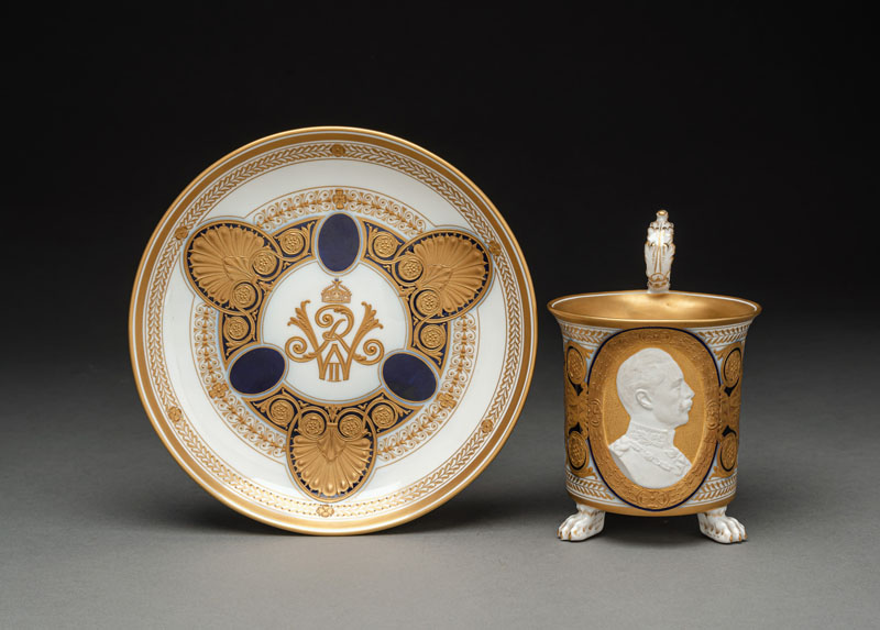 <b>A KPM BERLIN BLUE AND GOLD RELIEF TOOLED CUP AND SAUCER WITH A PORTRAIT OF KAISER WILHELM II</b>
