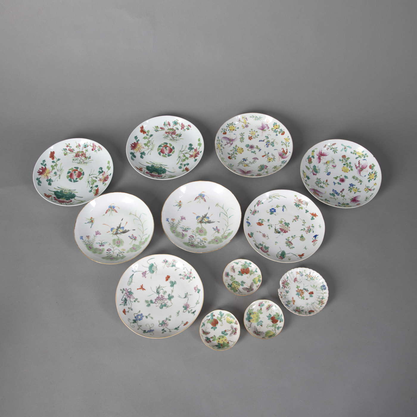 <b>A GROUP OF TWELVE 'FAMILLE ROSE' PORCELAIN PLATES AND BOWLS WITH BUTTERFLY, FLOWER AND FRUIT DECORATION</b>