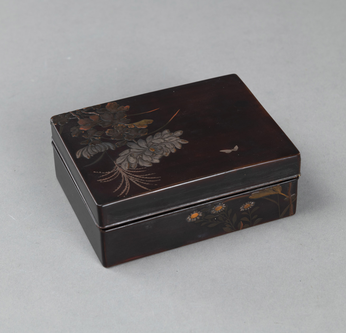 <b>A SMALL RECTANGULAR BOX AND COVER WITH POLYCHROME LACQUER DECORATION DEPICTING CHRYSANTHEMUMS AND A BUTTERFLY</b>
