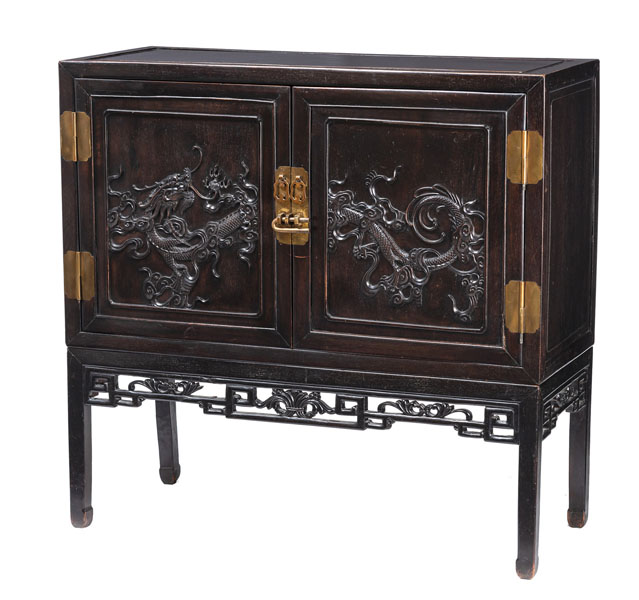 <b>A TWO-DOOR BRASS-MOUNTED DRAGON RELIEF CABINET ON A FOUR-LEGGED STAND</b>