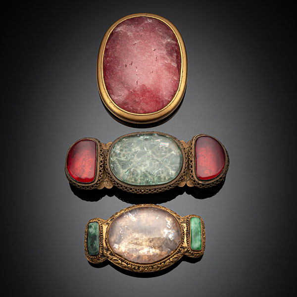 <b>Drei Gürtelschließen aus feuervergoldeter Bronze mit Rosenquarz-, Kristall oder Jadeit-Einlagen</b>