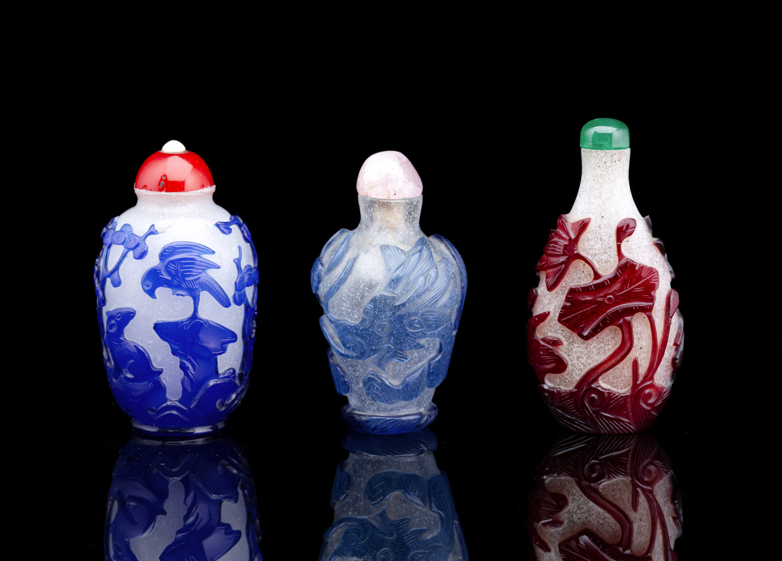 <b>Drei Snuffbottles aus Pekingglas mit rotem, hellblauem bzw. königsblauem Überfang</b>