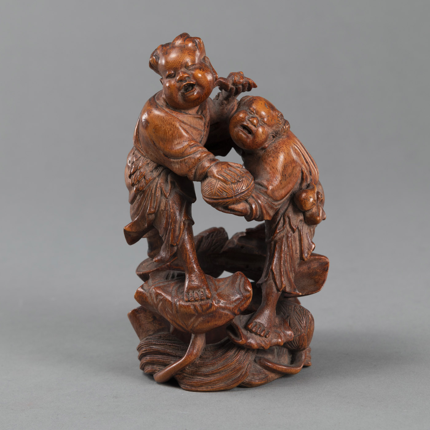 <b>A BAMBOO CARVING DEPICTING THE TWO IMMORTALS 'HE-HE ER XIAN' STANDING ON LOTUS</b>