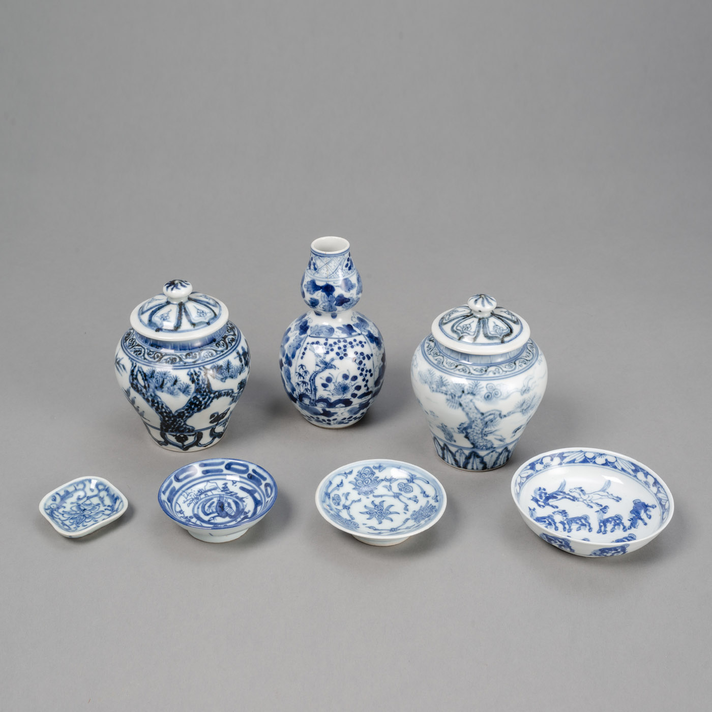 <b>A GROUP OF BLUE AND WHITE PORCELAIN PIECES, E.G. TWO LIDDED VASES, ONE 'HULUPING', A HORSES DISH</b>