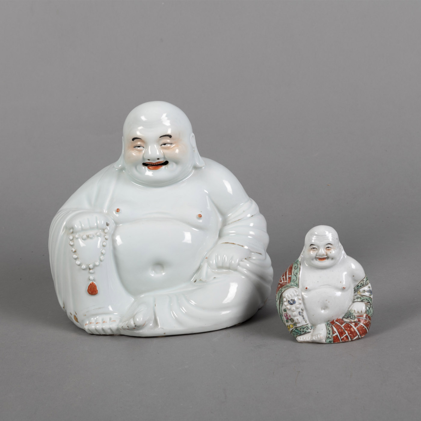 <b>Zwei polychrom bemalte Porzellanfiguren des Budai</b>