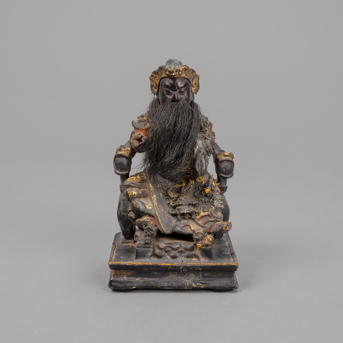 <b>A WOOD CARVING OF A GENERAL SEATED ON A HORSESHOE-BACK CHAIR WITH REMANTS OF GILDING AND POLYCHROME PAINTING</b>