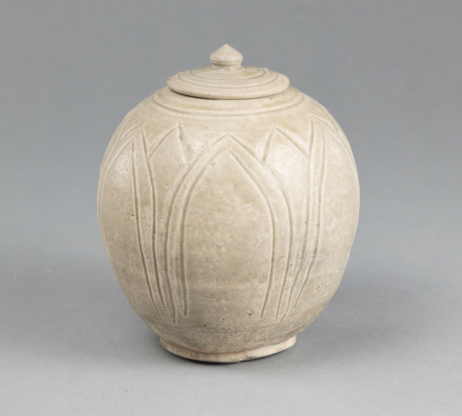 <b>A SPHERICAL YUE GREEN GLAZED STONEWARE VASE WITH COVER, DECORATED WITH INCISED LOTUS LEAVES PATTERN</b>