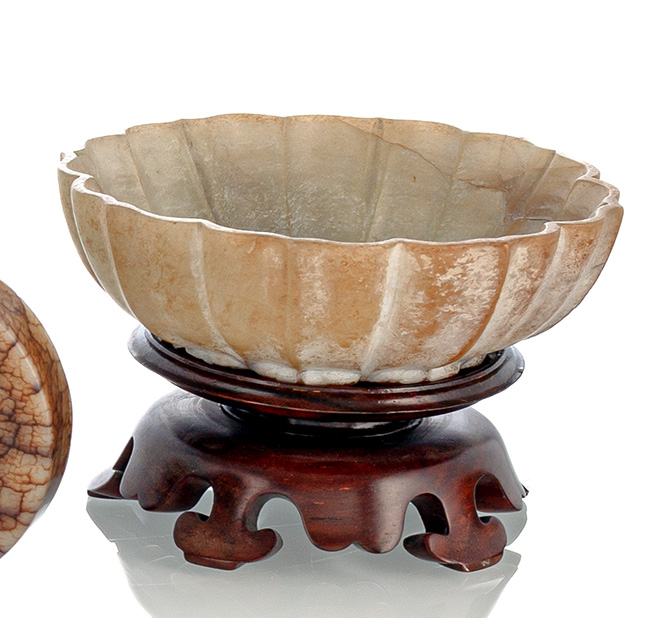 <b>A FINE CARVED BLOSSOM-SHAPED CORRODED JADE BOWL ON WOOD STAND</b>