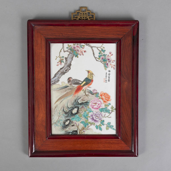<b>A PANEL WITH A FAMILLE ROSE PORCELAIN TILE DEPICTING A PAIR OF PHEASANTS ON A ROCK AND FLOWERING PEONIES AND A PEACH TREE</b>