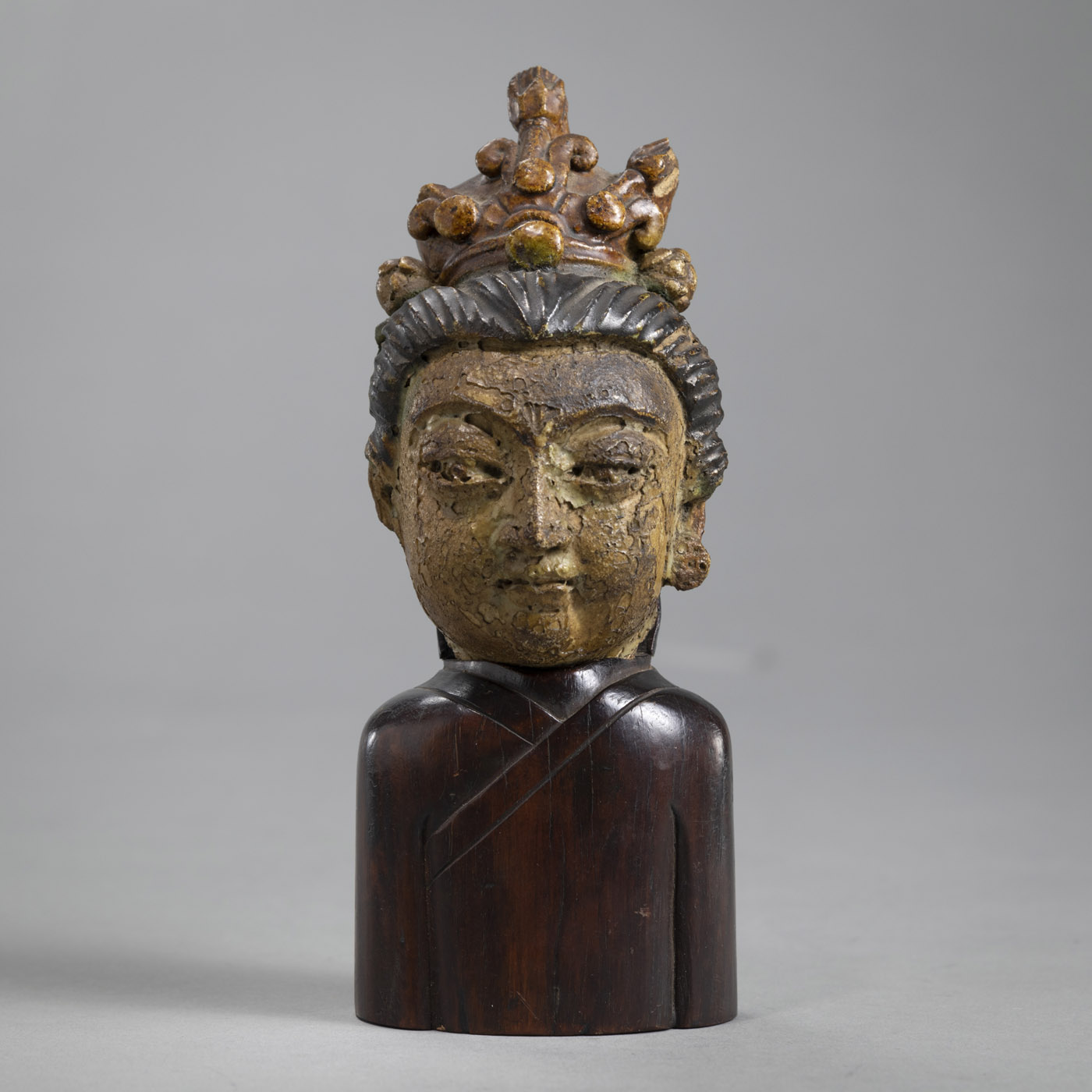 <b>Kleiner Terrakotta-Kopf des Guanyin, farbig gefasst, auf Holzständer in Form eines Oberkörpers</b>