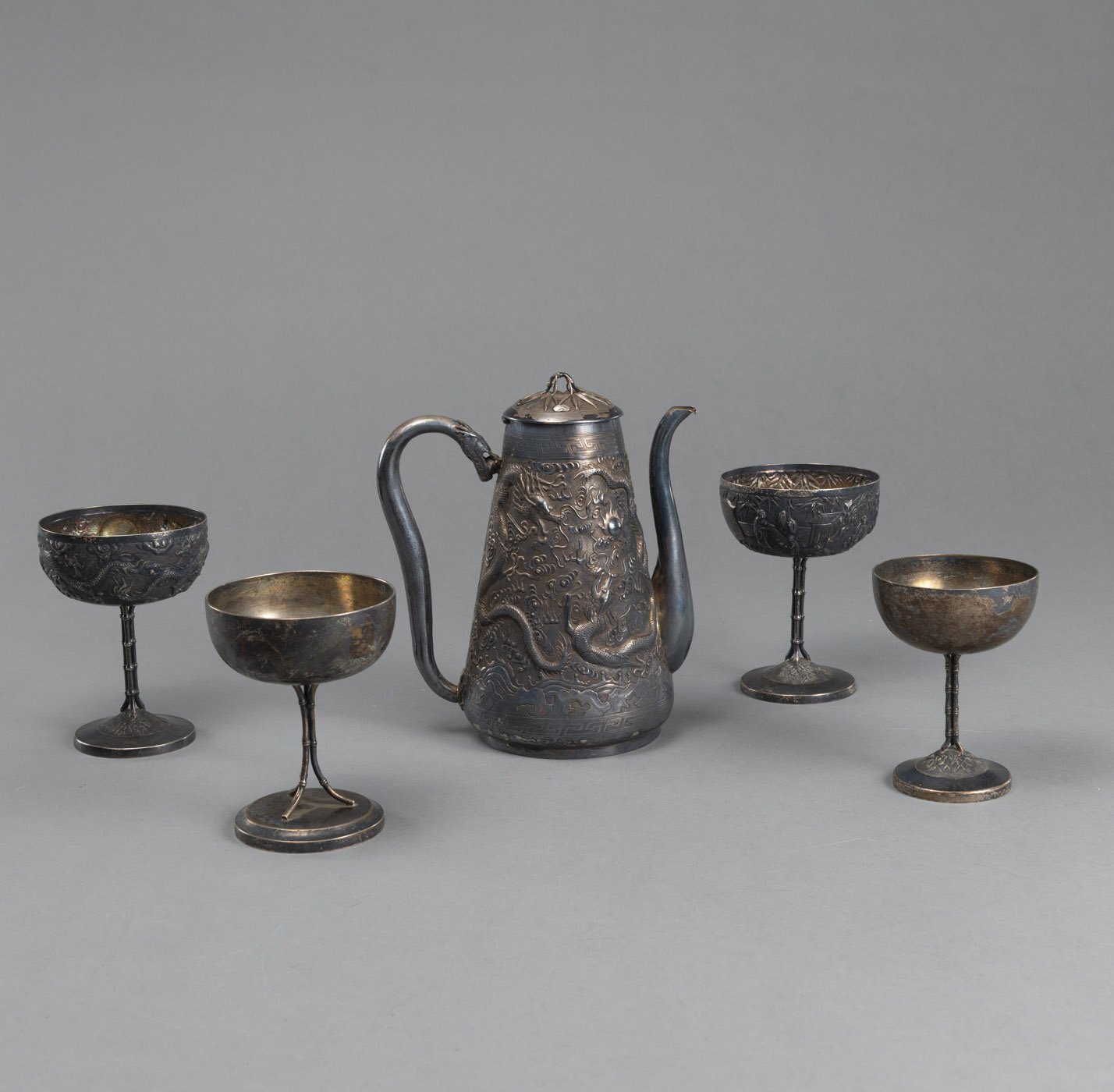 <b>A FIGURAL RELIEF SILVER EWER AND FOUR SILVER STEM CUPS</b>