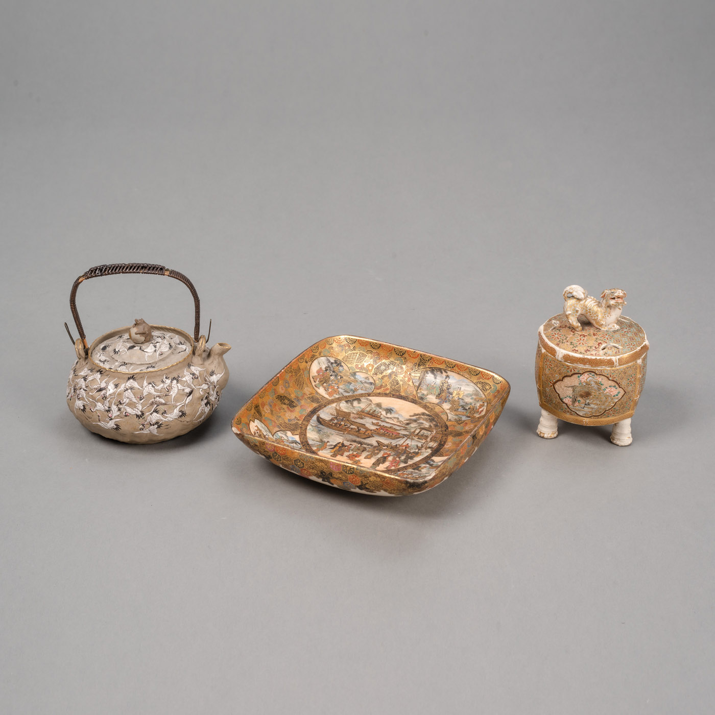 <b>Zwei Satsuma-Porzellane und eine mit Kranichen dekorierte Teekanne</b>