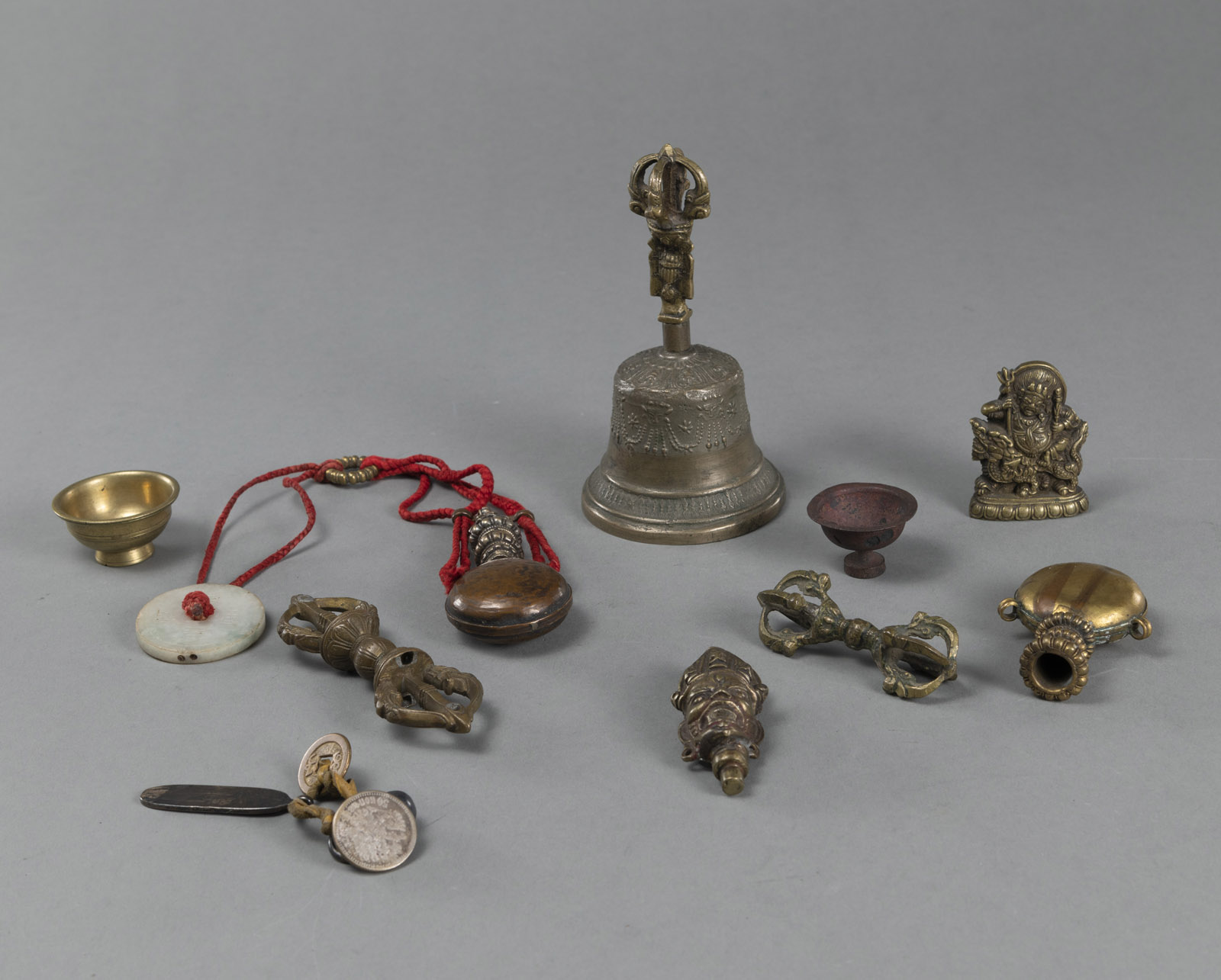<b>A GHANTA, TWO VAJRAS, A BUDDHIST BRONZE RELIEF, AND PENDANTS</b>