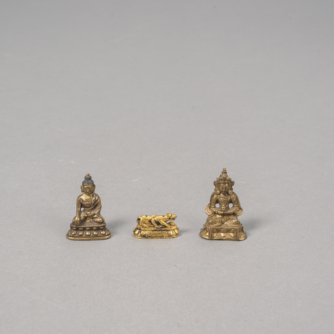 <b>TWO MINIATURE BRONZE FIGURINES OF BUDDHA AND AMITAYUS, AND A MINIATURE GILT-BRONZE BOVINE BASE</b>