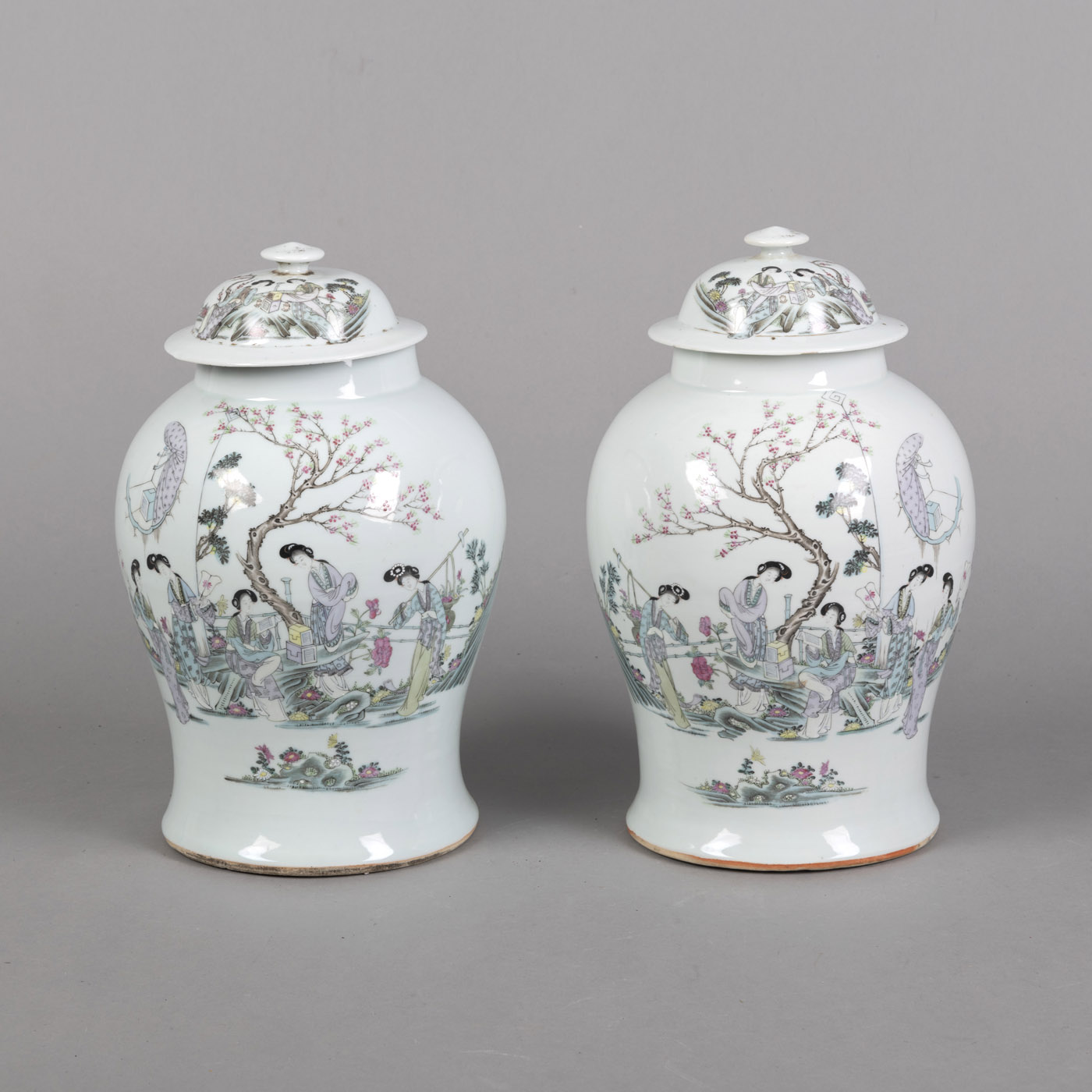 <b>Paar 'qianjiangcai'-Deckelvasen mit eleganten Damen im Garten und Aufschrift</b>