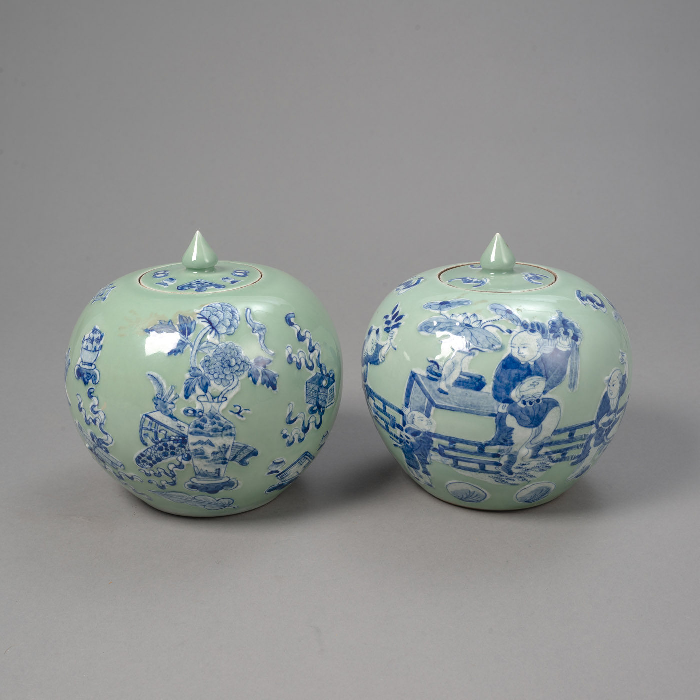 <b>Zwei Seladon-Deckelvasen aus Porzellan mit Knaben- und Antiquitätendekor in Unterglasurblau</b>