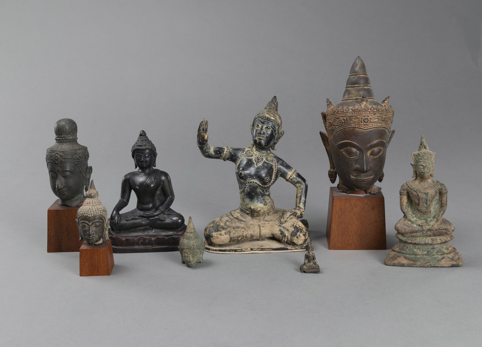 <b>FOUR BRONZE HEADS OF BUDDHA AND FOUR SCULPTURES</b>