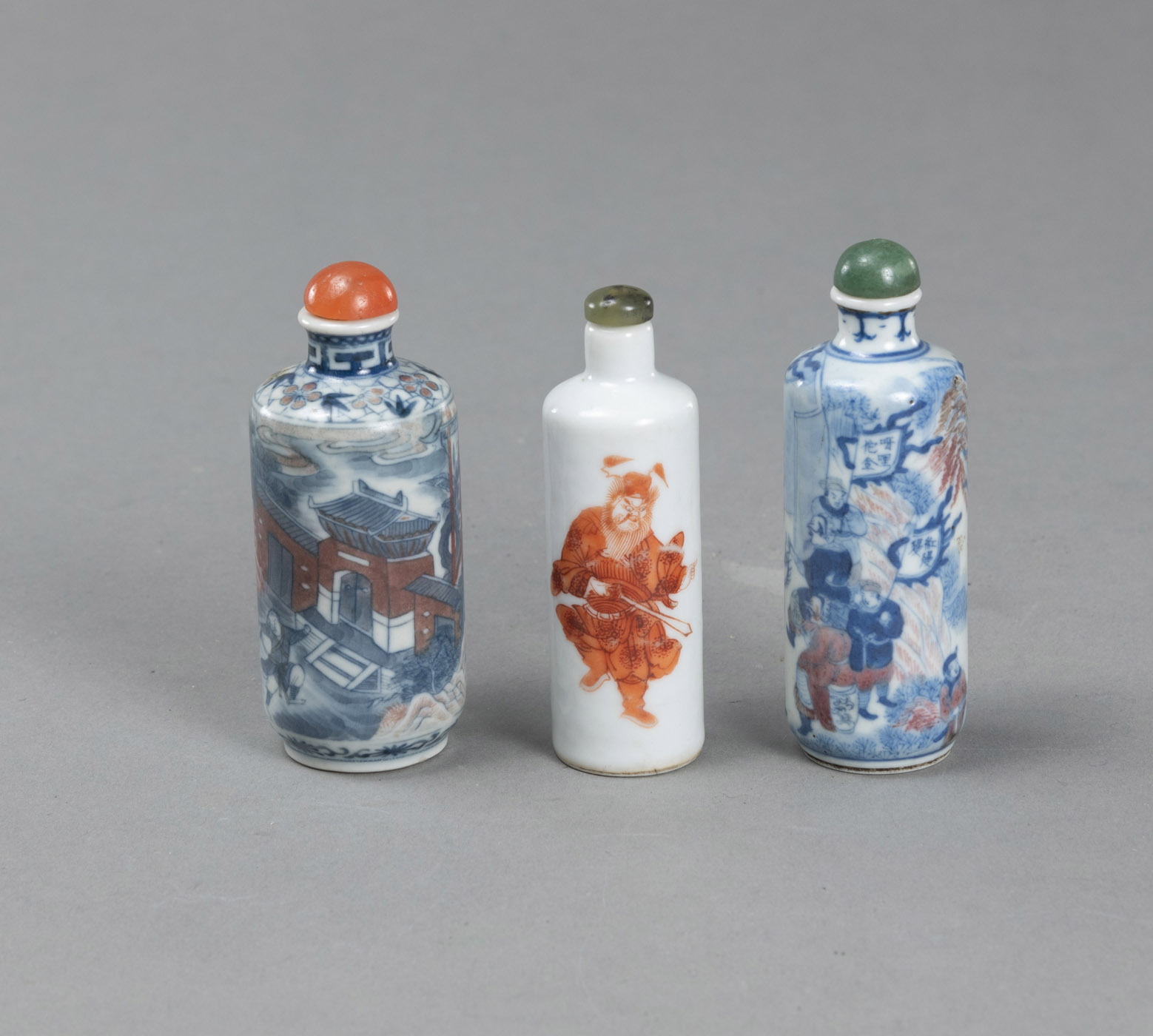 <b>Drei Snuffbottles aus Porzellan mit unterglasurblauem und eisenrotem Figurendekor</b>