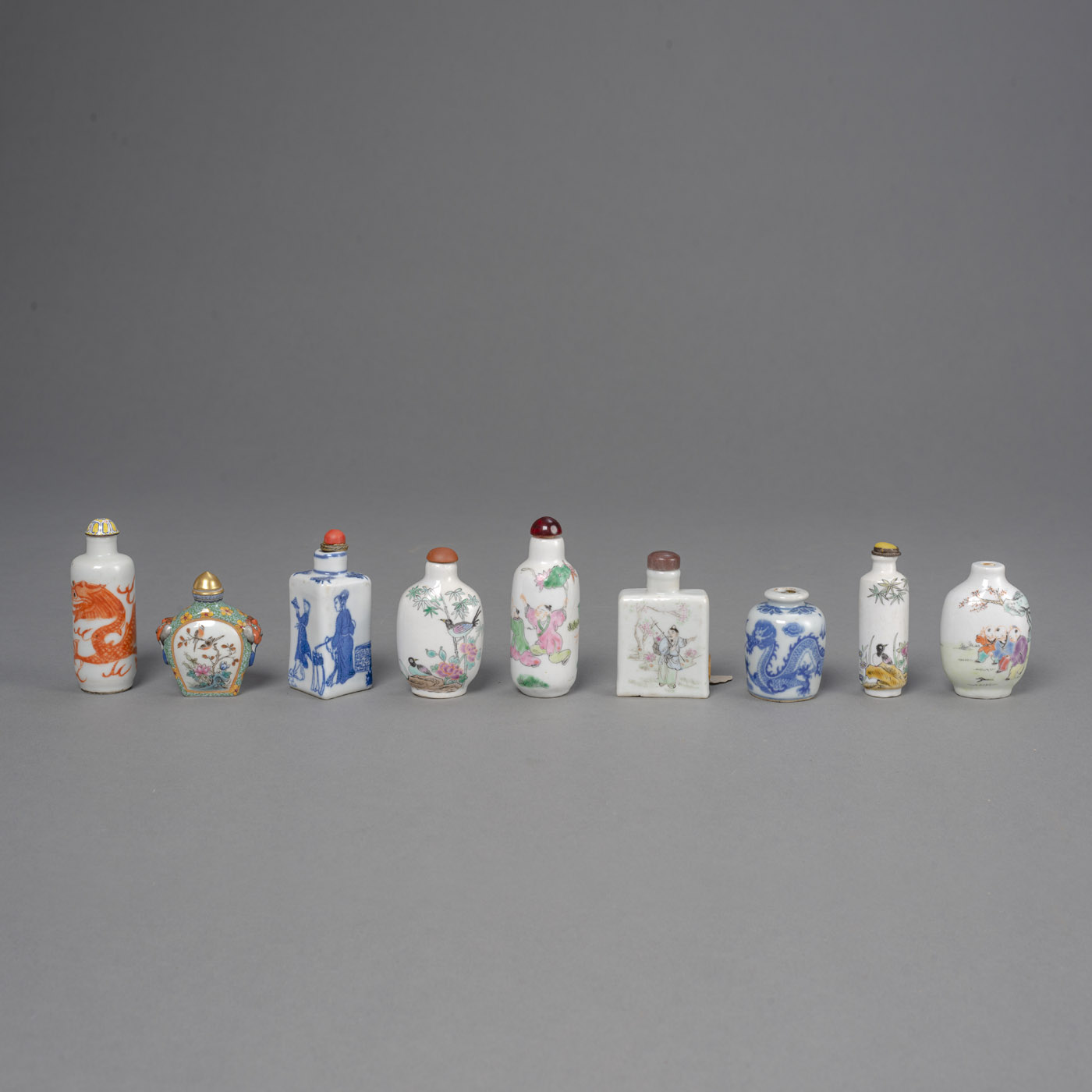 <b>Neun Snuffbottles aus Porzellan mit unterglasurblauem und polychromer Malerei</b>