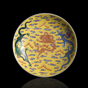 <b>Großer Teller aus Porzellan mit polychromem Dekor von fünf Drachen auf gelben Grund</b>
