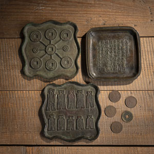<b>Drei Tabletts aus Bronze mit Münzdekor und Inschrift sowie fünf Münzen</b>