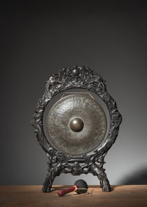 <b>A GONG MOUNTED IN A FINELY CARVED WOOD STAND</b>