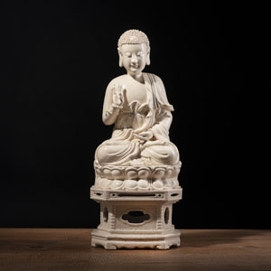 <b>A CREME-GLAZED PORCELAIN FIGURE OF BUDDHA</b>