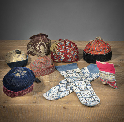 <b>A GROUP OF SIX LEATHER AND SILK HATS, A PAIR OF SOCKS, AND A SHOE</b>