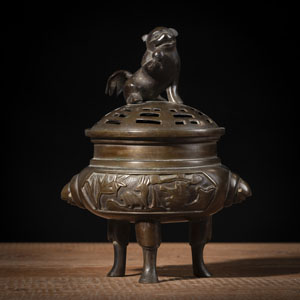 <b>Dreibeiniger Weihrauchbrenner aus Bronze mit in Durchbruch gearbeitetem Deckel bekrönt mit einem sitzenden Wächterlöwen</b>
