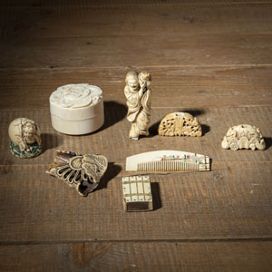 <b>TWO FAN HOLDERS, A ROUND LIDDED DRAGON BOX, A NETSUKE OF THE GAMA SENNIN, AN INLAID SHIBAYAMA COMB, AN OKIMONO AND AN IVORY MATCHBOX. ADDITIONALLY A STAGANTLER CHRYSANTHEMUM NETSUKE</b>