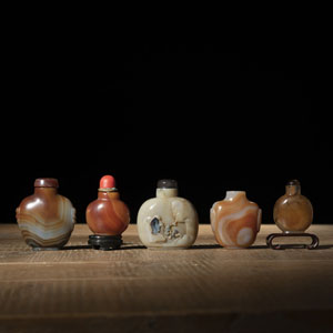 <b>FIVE AGATE SNUFF BOTTLES, ONE CARVED WITH A SCHOLAR IN A GARDEN LANDSCAPE</b>