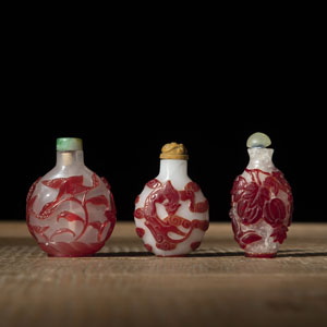 <b>THREE PEKING GLASS SNUFF BOTTLES WITH RED OVERLAY DEPICTING WILD GEESE, CHILONG, PHOENIX AND MELON FRUITS</b>