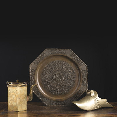 <b>A BRASS EWER AND STIRRUP, AND AN OPENWORK TWIN FISH BRONZE PLATE</b>
