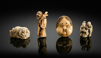 <b>Gruppe von vier Netsuke aus Elfenbein: Maske, Sennin, Knabe an Felsen und Paar</b>