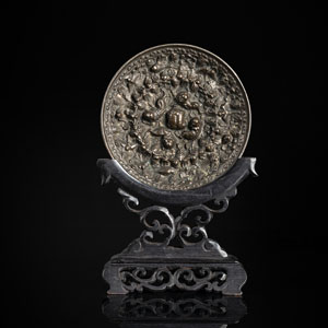 <b>Spiegel aus silberfarbener Bronze mit Trauben-Löwen-Dekor im Tang-Stil auf Holzstand</b>