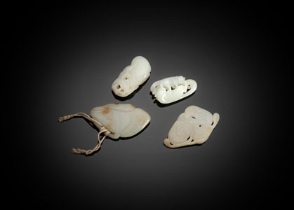 <b>A GROUP OF FOUR FINE CARVED JADE PENDANTS</b>