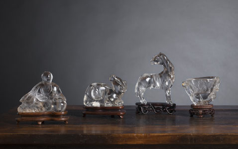 <b>A GROUP OF FOUR CRYSTAL CARVINGS ON WOOD STANDS</b>