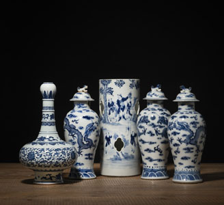 <b>Drei Deckelvasen, ein Hutständer und eine Knoblauchkopf-Vase aus Porzellan mit unterglasurblauem Dekor von Lotos, Drachen und Figuren</b>